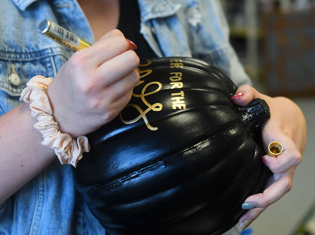 Morgan Cossey customizes a pumpkin with the quote "Here for the Boos"